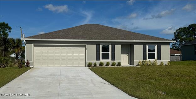 ranch-style home featuring a garage and a front lawn