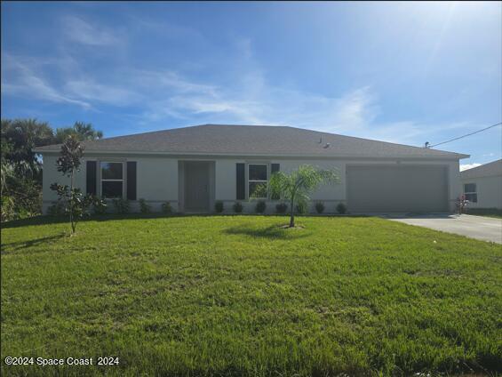 ranch-style house with a garage and a front lawn