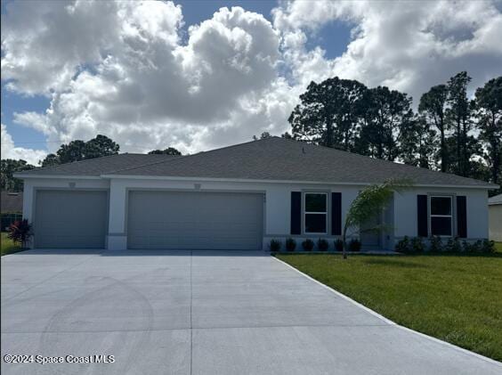 single story home with a garage and a front lawn