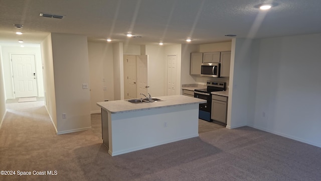 kitchen with a kitchen island with sink, sink, gray cabinets, light colored carpet, and stainless steel appliances