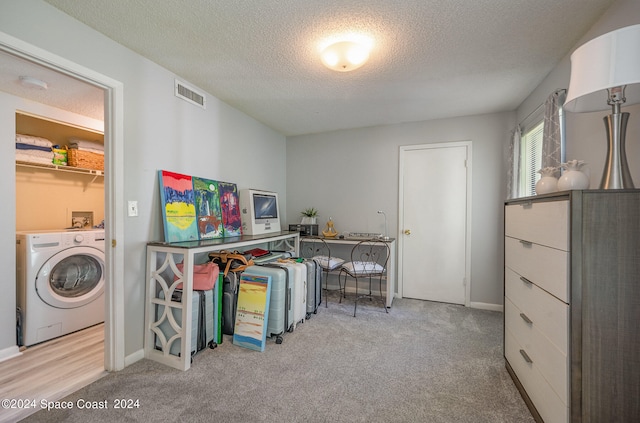 carpeted office space with washer / clothes dryer and a textured ceiling