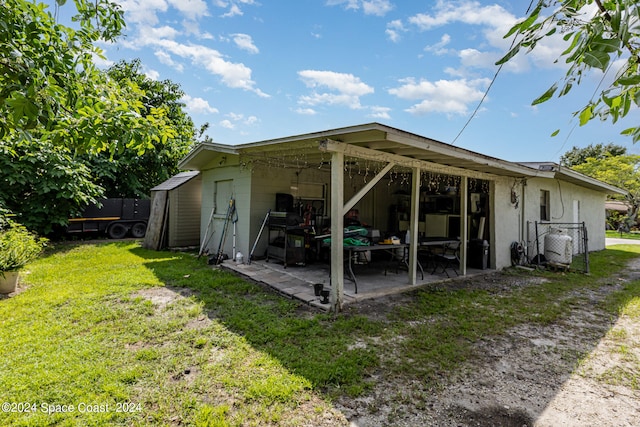 back of property with a patio and a yard