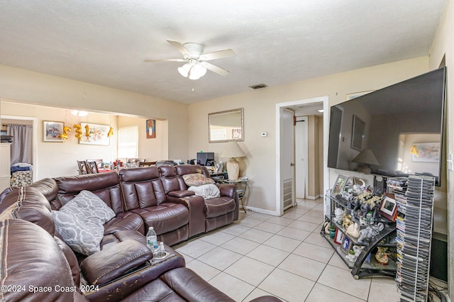 living room with a textured ceiling, light tile patterned floors, and ceiling fan