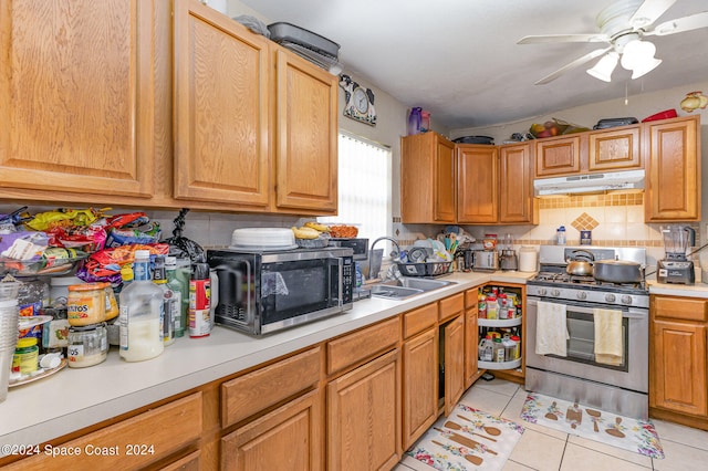 kitchen featuring tasteful backsplash, light tile patterned floors, stainless steel appliances, ceiling fan, and sink