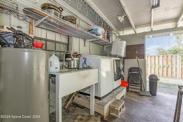 utility room with water heater and washer and dryer