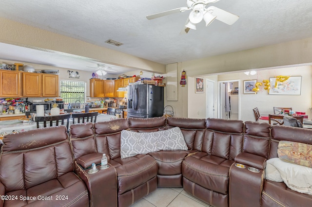 tiled living room featuring a textured ceiling and ceiling fan