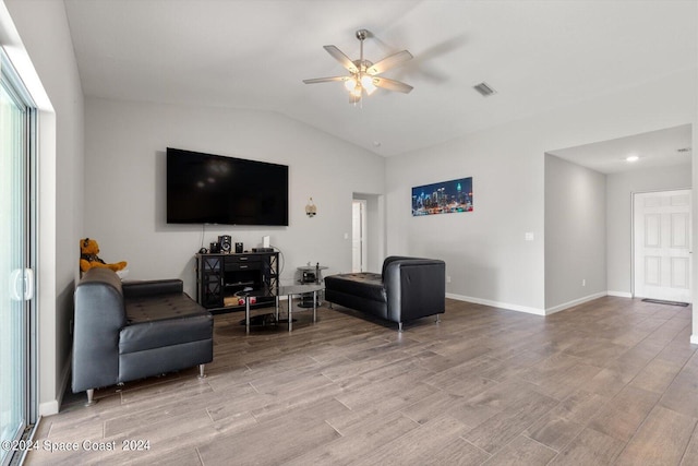 living room with ceiling fan, light hardwood / wood-style flooring, and lofted ceiling