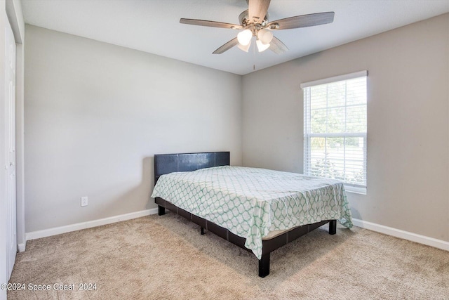 bedroom featuring ceiling fan, light colored carpet, and a closet