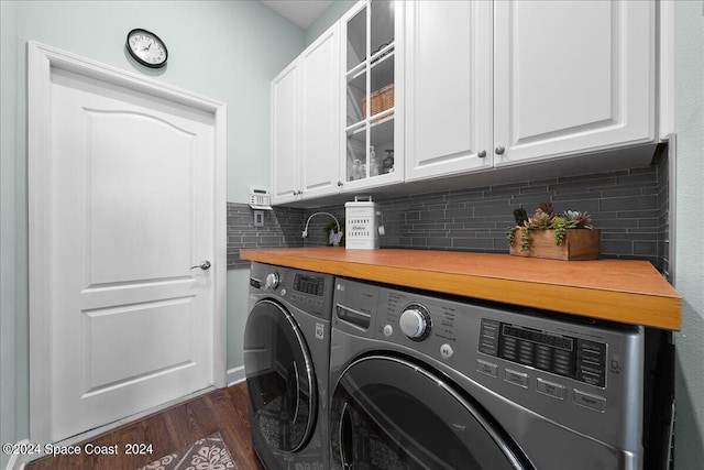 laundry room with cabinets, washer and dryer, and dark hardwood / wood-style floors