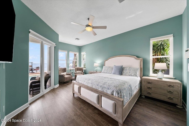 bedroom with ceiling fan, a textured ceiling, and dark hardwood / wood-style floors