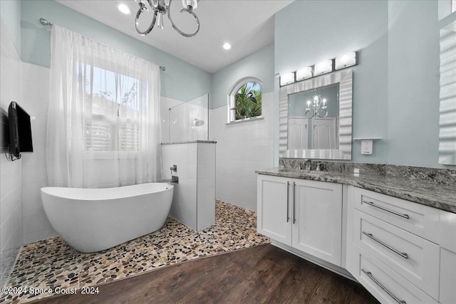 bathroom featuring vanity, an inviting chandelier, hardwood / wood-style floors, and independent shower and bath