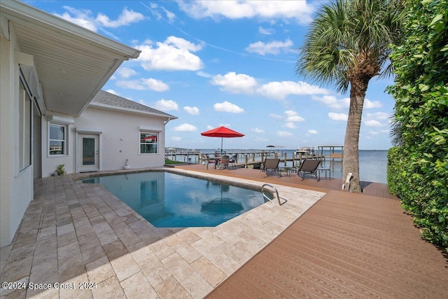 view of swimming pool with a patio area and a water view