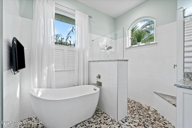 bathroom with vanity, shower with separate bathtub, tile patterned floors, and tile walls