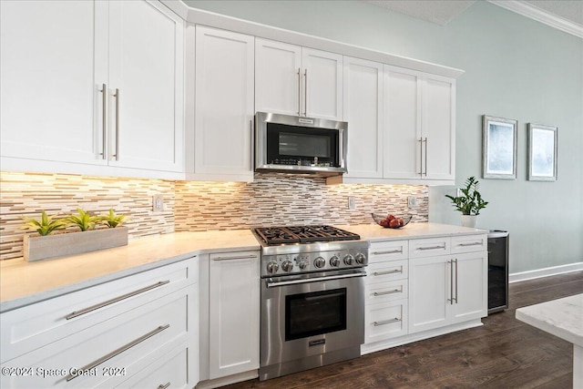 kitchen with white cabinets, backsplash, dark hardwood / wood-style flooring, ornamental molding, and stainless steel appliances