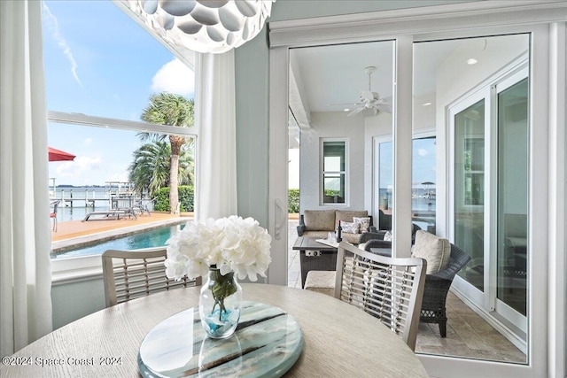 dining room featuring a water view and ceiling fan