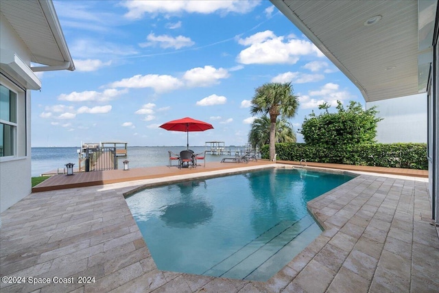 view of swimming pool featuring a patio area and a deck with water view