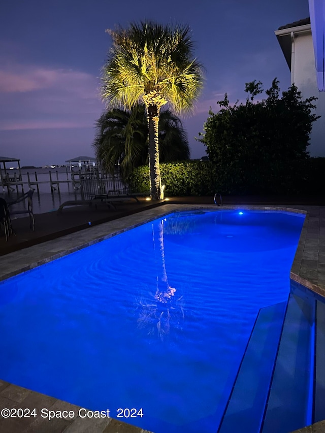 view of pool at dusk