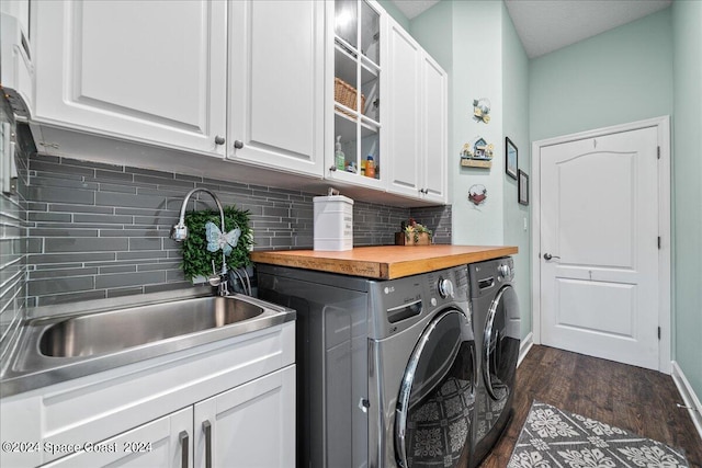 washroom featuring sink, washer and dryer, cabinets, and dark hardwood / wood-style floors