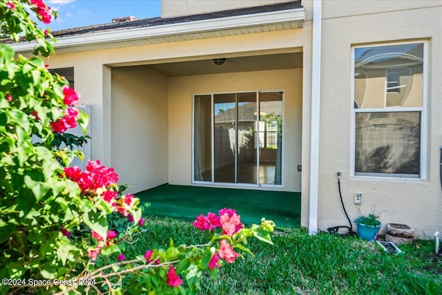 view of exterior entry with a lawn