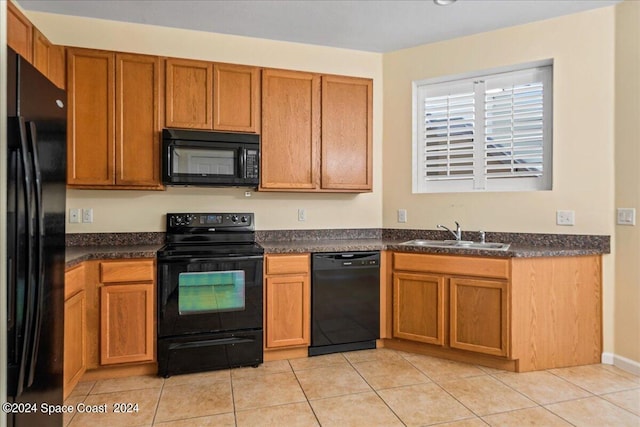 kitchen featuring black appliances, sink, and light tile patterned floors