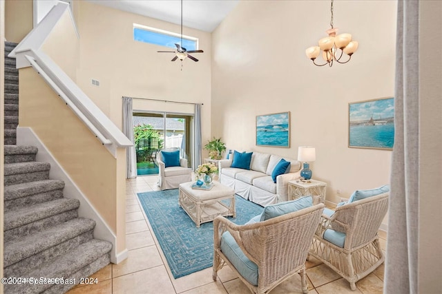 living room featuring ceiling fan with notable chandelier, a towering ceiling, and light tile patterned floors