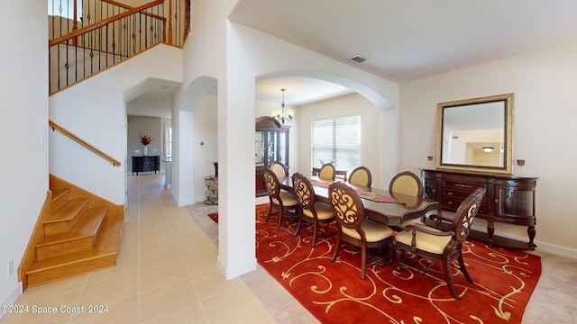 dining area featuring light tile patterned flooring and a notable chandelier