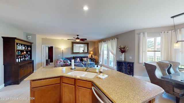 kitchen with an island with sink, ceiling fan, a healthy amount of sunlight, and sink