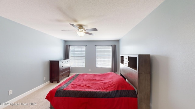 carpeted bedroom featuring ceiling fan and a textured ceiling