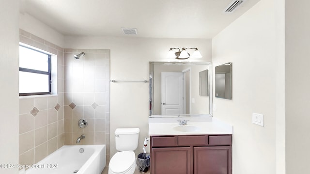 full bathroom featuring tiled shower / bath, vanity, and toilet