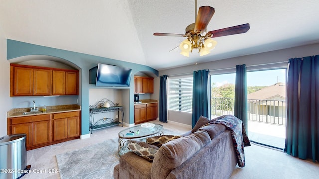 carpeted living room featuring ceiling fan, a textured ceiling, sink, and vaulted ceiling