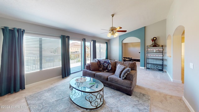 carpeted living room with ceiling fan and a textured ceiling