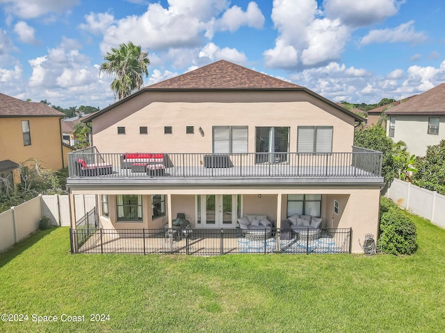 back of house featuring a lawn, a patio, and a balcony