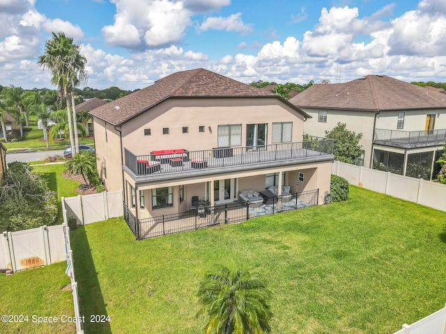 back of property with a balcony, a lawn, and a patio area