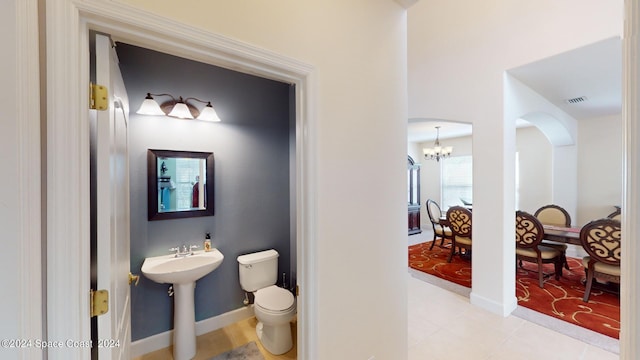 bathroom with a notable chandelier, hardwood / wood-style flooring, and toilet