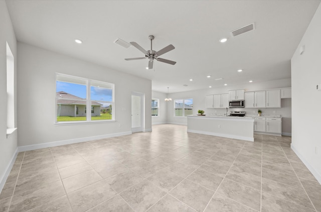 unfurnished living room with light tile patterned floors and ceiling fan