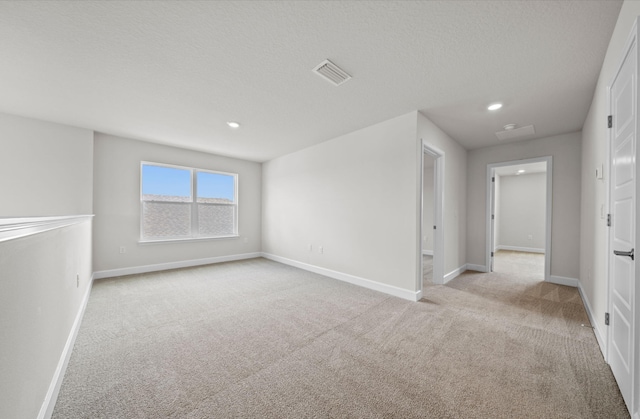 carpeted spare room with a textured ceiling