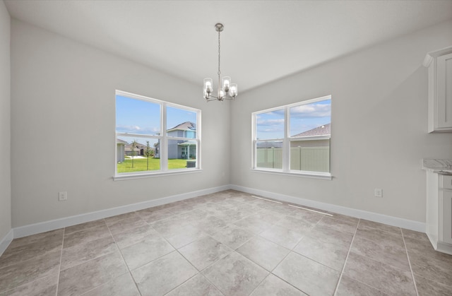 unfurnished dining area featuring a wealth of natural light, a chandelier, and light tile patterned flooring