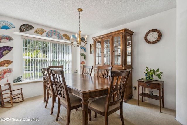 carpeted dining area with a chandelier and a textured ceiling