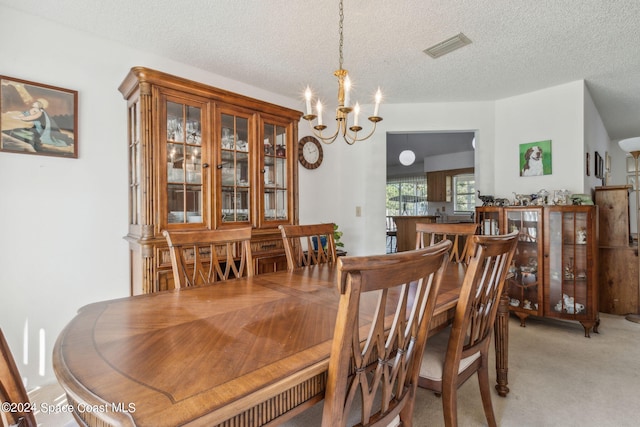 dining area with light colored carpet, an inviting chandelier, and a textured ceiling