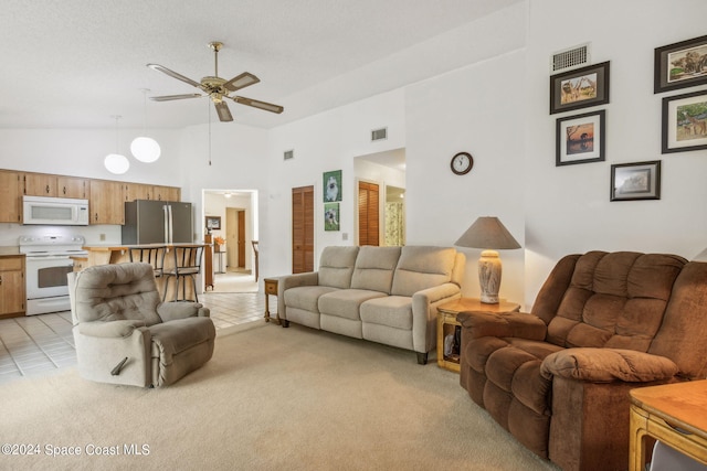 living room featuring light carpet, high vaulted ceiling, and ceiling fan