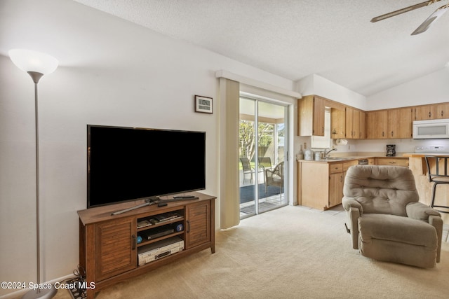 carpeted living room featuring ceiling fan, a textured ceiling, lofted ceiling, and sink