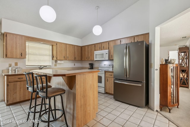 kitchen with light tile patterned flooring, hanging light fixtures, vaulted ceiling, and white appliances