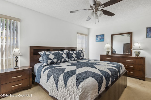 carpeted bedroom with a textured ceiling and ceiling fan