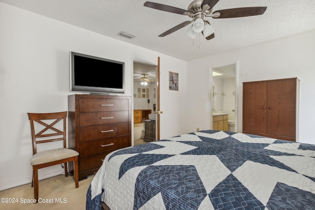 carpeted bedroom featuring ceiling fan, a textured ceiling, and ensuite bathroom