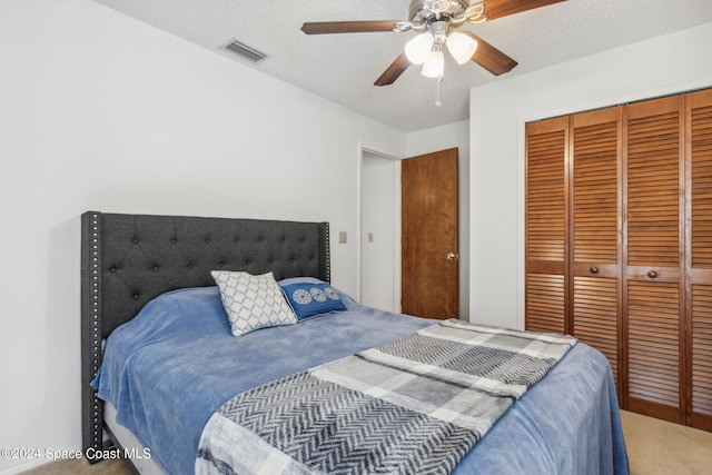 bedroom featuring carpet floors, a textured ceiling, a closet, and ceiling fan