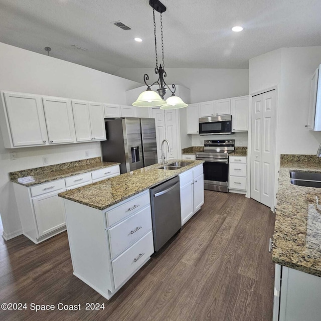 kitchen featuring stainless steel appliances, white cabinets, and vaulted ceiling