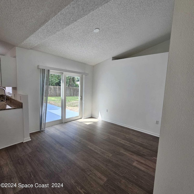 interior space featuring lofted ceiling, a textured ceiling, sink, and dark hardwood / wood-style flooring