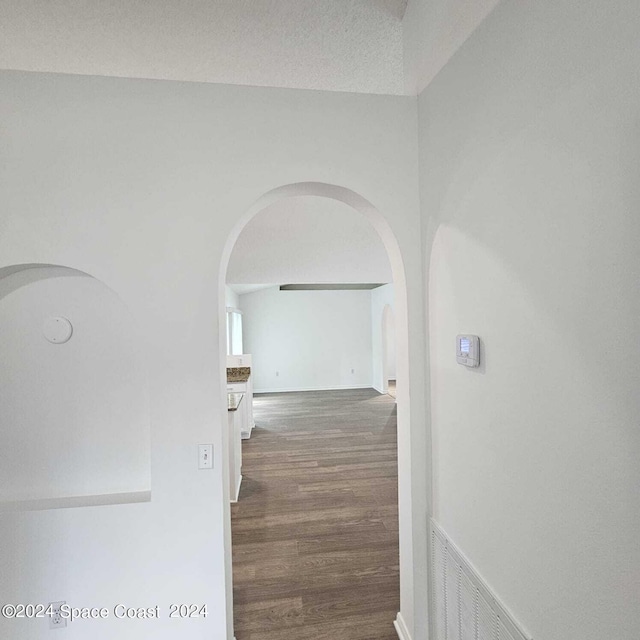 hallway featuring a textured ceiling and dark hardwood / wood-style flooring