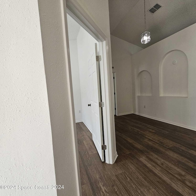 hall with an inviting chandelier and dark hardwood / wood-style flooring