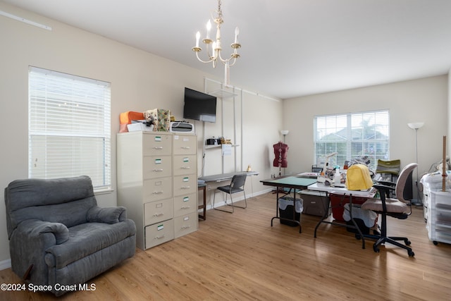 office space with light hardwood / wood-style floors and a notable chandelier